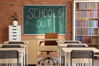 Sınıf içi tuğla duvarda yazılı yazı tahtası var.