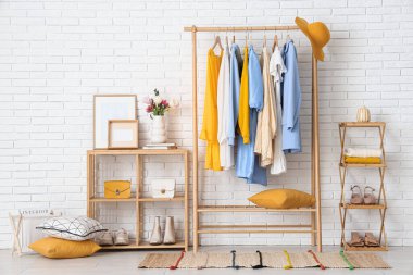 Giysi askılığı ve raf üniteleriyle aydınlık soyunma odasının içinde.