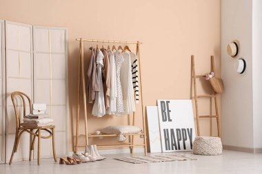 Elbise askılığı, sandalye ve katlama perdesi olan şık bir soyunma odası.