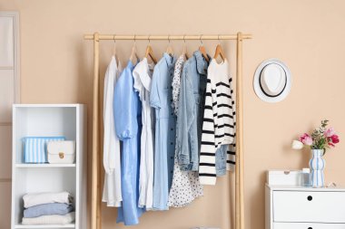 Giysi askısı, raf ünitesi ve tuvalet masası olan şık bir soyunma odası.