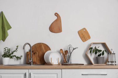 Lavabo, tabak ve farklı mutfak aletleriyle ahşap tezgah.