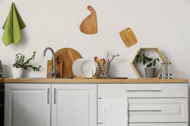 Lavabo, tabak ve farklı mutfak aletleriyle ahşap tezgah.