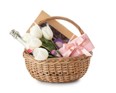 Beyaz arka planda bahar çiçekleri, şampanya, şeker ve kozmetik içeren hediye sepeti.