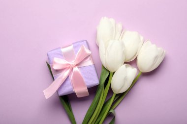 Güzel beyaz lale çiçekleri ve leylak arkaplanlı hediye kutusu. Anneler Günü kutlaması