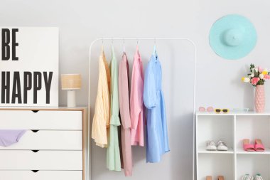 Kadın kıyafetleri, ayakkabıları ve posterleri olan modern bir soyunma odası.