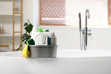 Banyodaki küvette temizlik malzemesi olan plastik bir leğen.