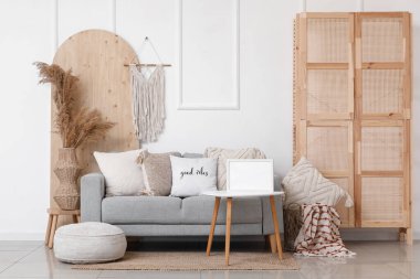 Gri kanepeli ve kahve masasında boş çerçeveli şık bir oturma odası.