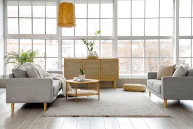 Kanepeleri, masası ve geniş pencereli modern stüdyo dairesi.