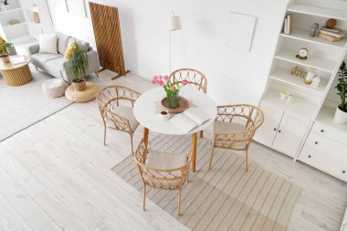 Modern stüdyo dairesinin içinde yemek masası ve kanepesi var.