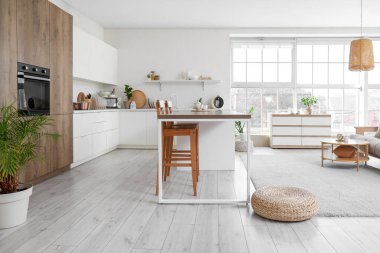 Mutfağın içi masa, tezgah ve bitkilerle dolu.