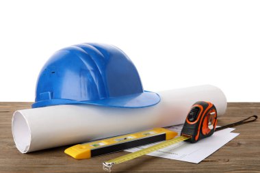 Katı şapka, plan ve inşaat araçları beyaz arka plana karşı ahşap masa üzerinde