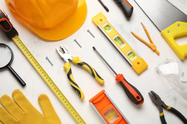 Beyaz grunge arkaplan üzerinde farklı inşaat araçları ve sabit şapka düzenleme