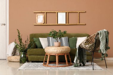 Oturma odasında yeşil kanepe, koltuk ve merdiven var.