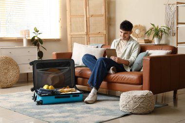 Erkek turist evde paketlenecek şeylerin kontrol listesini yazıyor