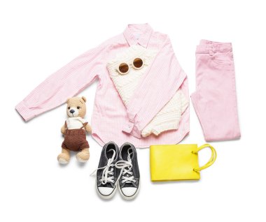 Beyaz arka planda aksesuarları ve oyuncak ayıları olan şık çocuk kıyafetleri.