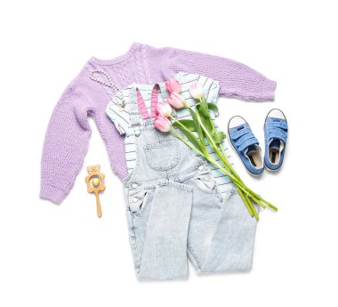 Beyaz arka planda çıngıraklı ve laleli çocuk kıyafetleri