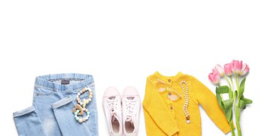 Beyaz arka planda çıngıraklı ve laleli çocuk kıyafetleri