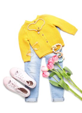 Beyaz arka planda çıngıraklı ve laleli çocuk kıyafetleri