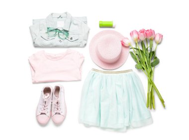 Beyaz arka planda aksesuarları ve laleleri olan şık çocuk kıyafetleri.