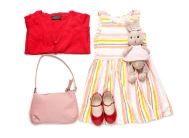 Beyaz arka planda oyuncak tavşan olan şık çocuk kıyafetleri.