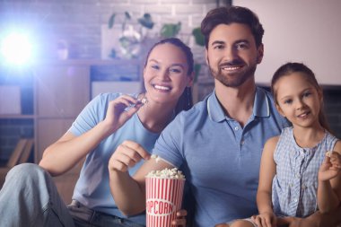Aile evde film izlerken patlamış mısır yiyor.