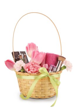 Güzel bahar çiçekleri, hediye kutuları ve beyaz arka planda makyaj fırçaları olan sepet.