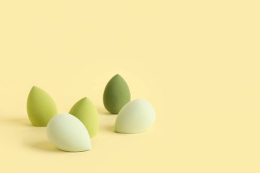 Sarı arkaplanda yeşil makyaj süngeri