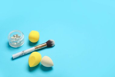 Mavi arkaplanda fırça ve fosforlu makyaj süngerleri