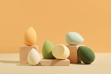 Bej arka planda makyaj süngeri olan dekoratif podyumlar