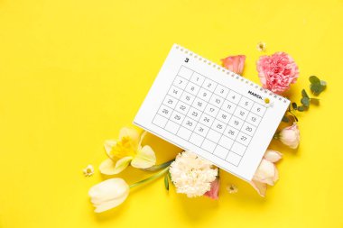 Mart ayının kağıt takvimine ve sarı arkaplanda güzel bahar çiçeklerine sahip kompozisyon