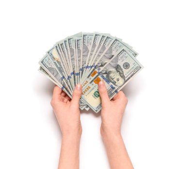 Beyaz arka planda 100 dolarlık banknotları olan kadın eller.