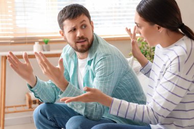 Genç bir adam evde karısıyla kavga ediyor.