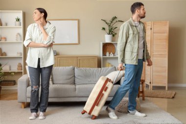 Bavullu genç adam karısını evde kavga ettikten sonra terk ediyor.