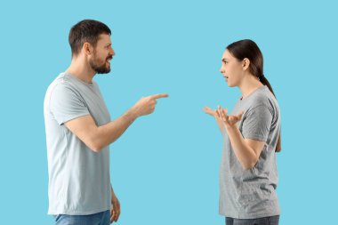 Mavi arka planda kavga eden genç çift.