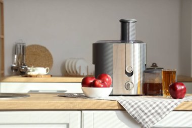 Mutfaktaki kırmızı elmalı modern meyve sıkacağı.