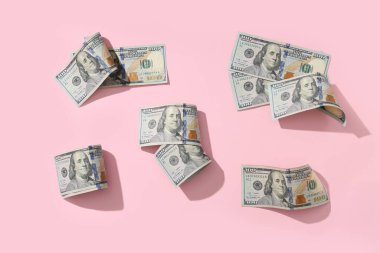 Pembe arka planda birçok dolarlık banknotlar