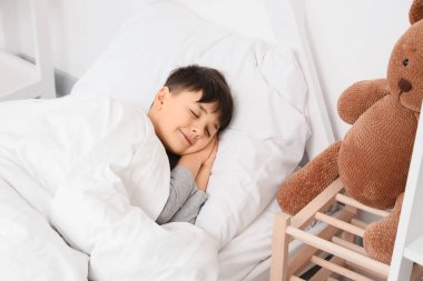 Evde yatakta uyuyan tatlı çocuk.