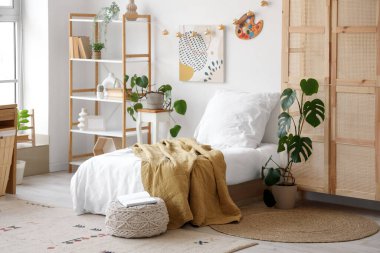 İçinde yatak, raf ve bitkiler olan ergen odasının içinde.