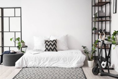 Yatağı, sentezleyicisi ve elektrikli scooterı olan bir gencin odası.