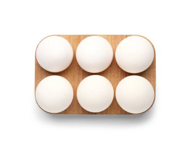 Beyaz arka planda taze tavuk yumurtası olan ahşap tutucu.