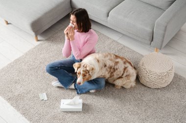 Evde kürke alerjisi olan köpek ve hapşıran genç kadın.