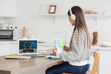 Genç kız mutfakta öğretmeniyle Matematik okuyor.