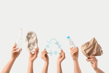 Geri dönüşüm işaretli kadın eller ve beyaz arka planda çöp. Ekoloji kavramı