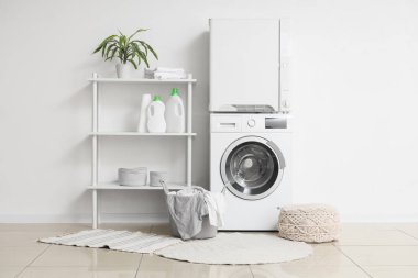 Çamaşır odasının içinde modern çamaşır makinesi ve çamaşır kurutma makinesi beyaz duvarın yanında.