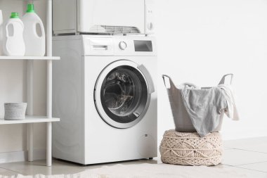 Çamaşır odasının içinde modern çamaşır makinesi ve çamaşır kurutma makinesi beyaz duvarın yanında.