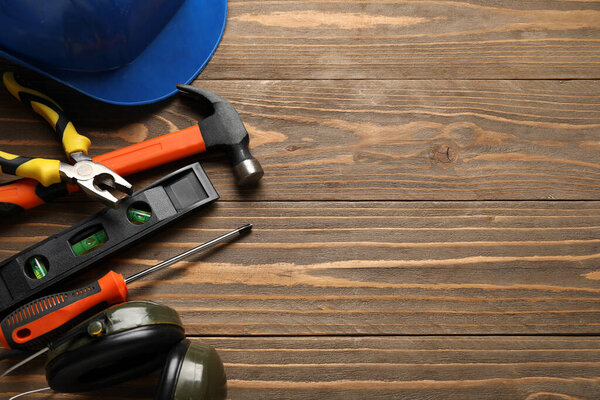 Hardhat and construction tools on wooden background