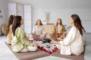 Kadınlar çemberinde meditasyon yapan bir grup genç kız.