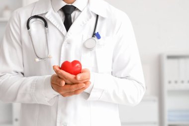 Ofiste kalbi olan erkek doktor, yakın plan.