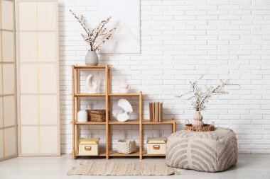 Raflı, perdeli, puf ve çiçek açan dalları olan ışık odasının içi.