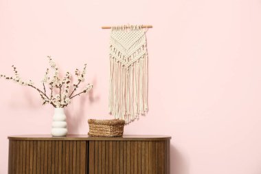 Odanın içinde çiçek açan dalları olan vazo.